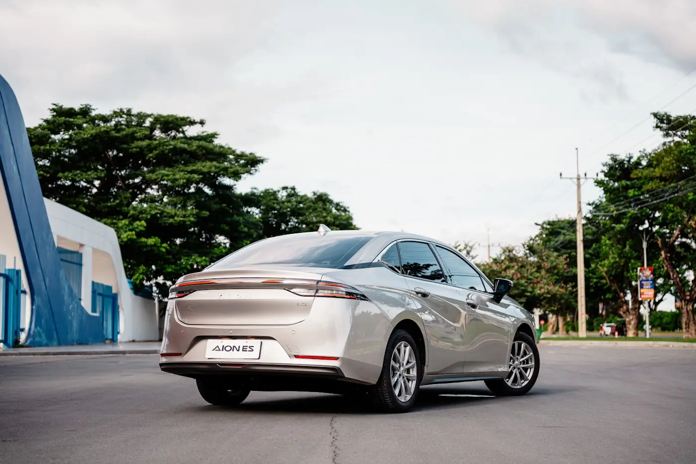 A silver sedan photographed from the rear three-quarter in daylight
