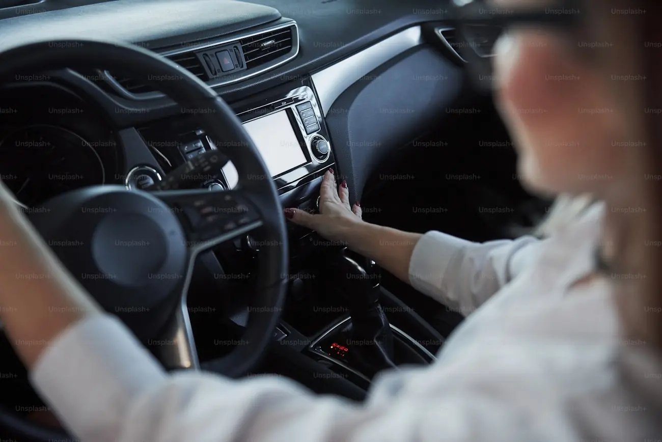 A driver&rsquo;s hands at the wheel and centre console of a modern car