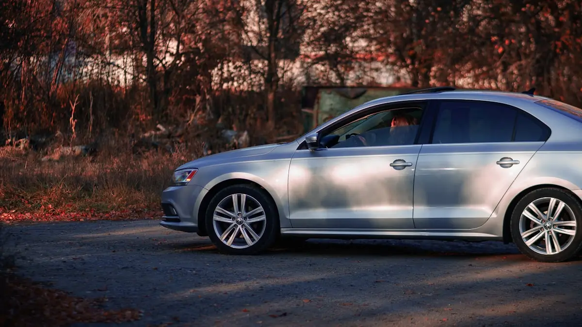 A silver sedan parked at the roadside in late autumn light